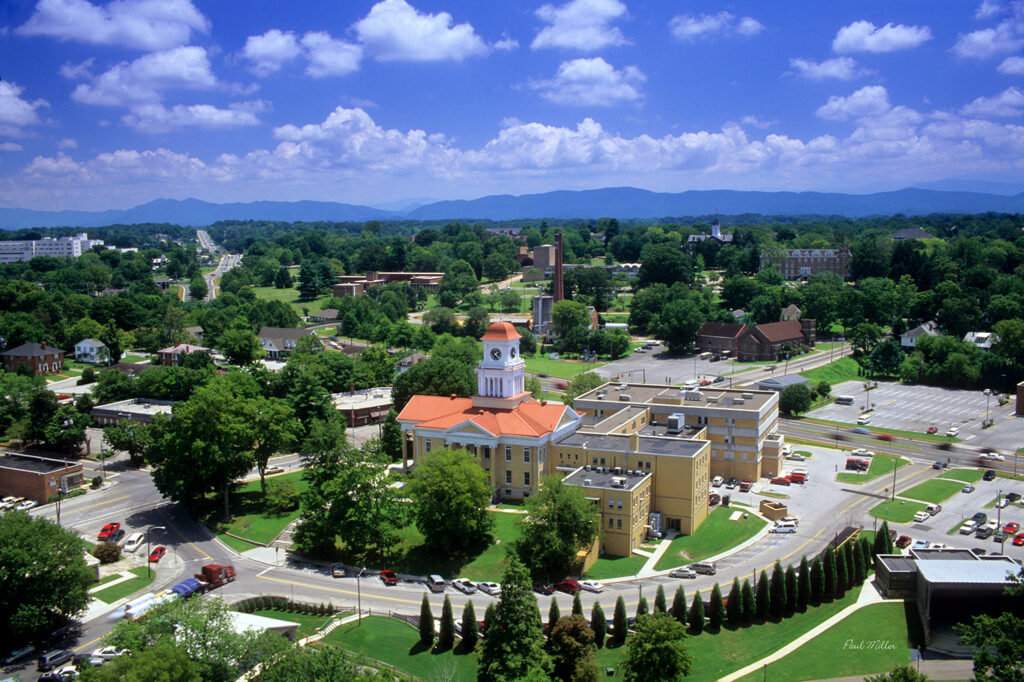 Aerial view of Maryville featuring a historic courthouse with a clock tower, surrounding neighborhoods, and scenic mountain backdrop.