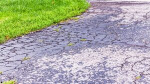 oxidized driveway asphalt before fall sealcoating treatment