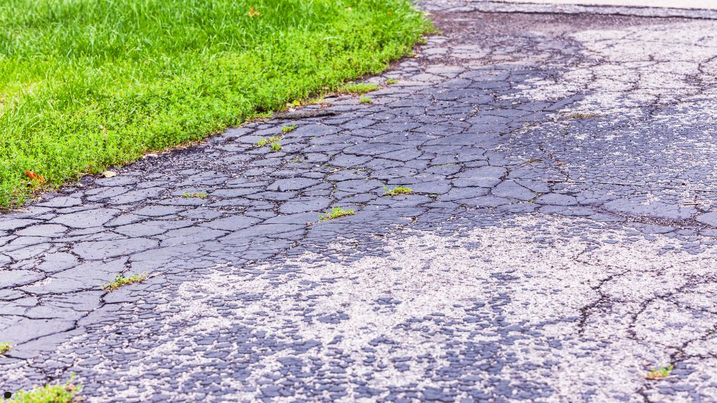 oxidized driveway asphalt before fall sealcoating treatment